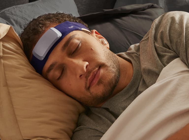 Man sleeping in bed, wearing a Muse S headband.